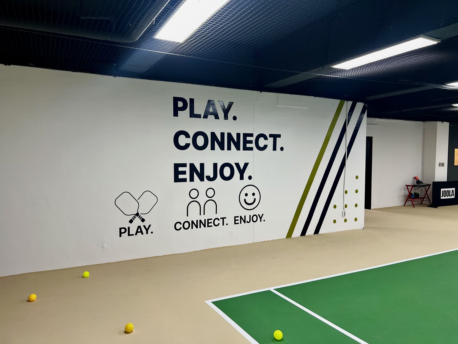 PLAY CONNECT ENJOY 문구가 그려진 조이피클볼 코트 벽면